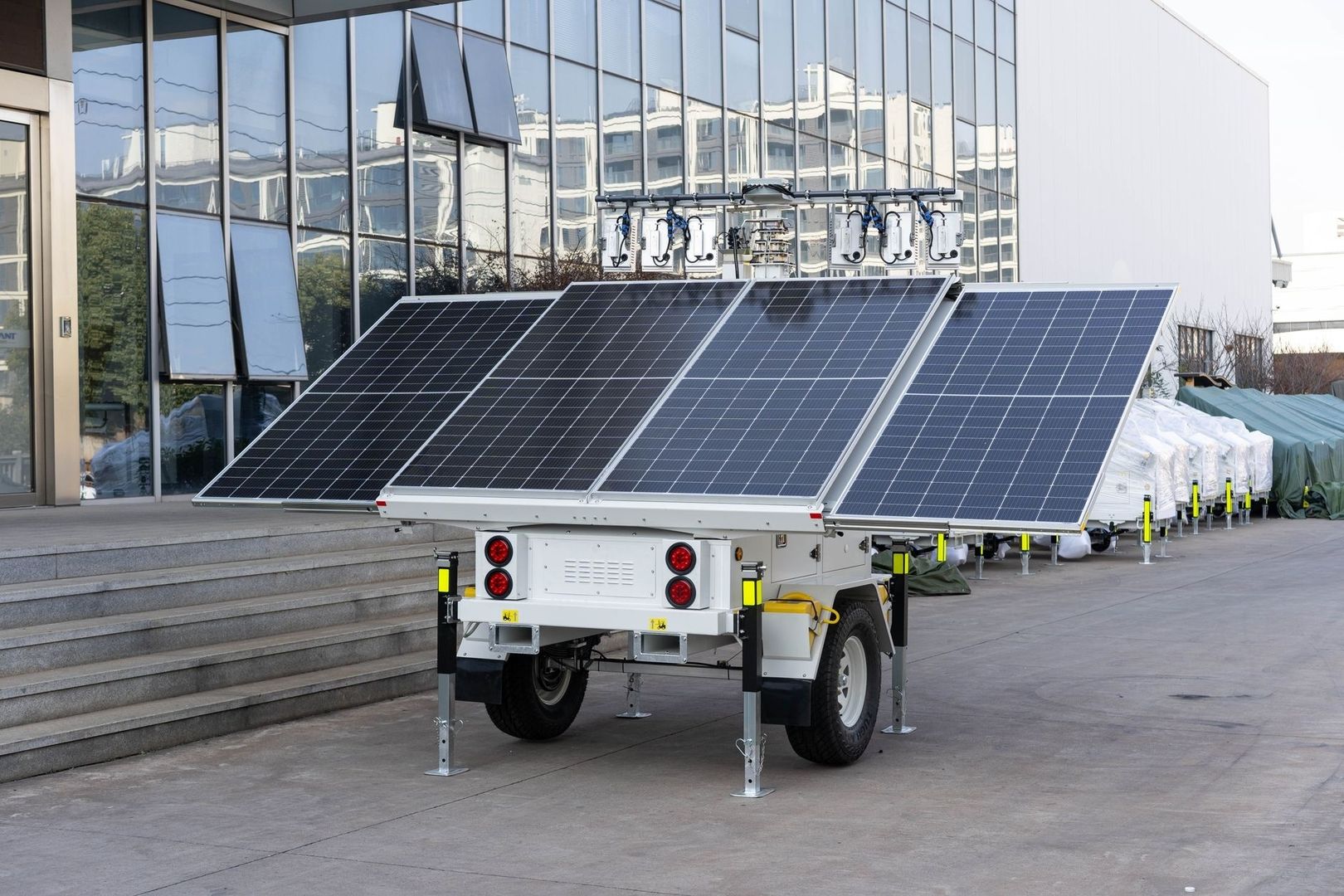 Mobiler Solarstrom-Anhänger mit mehreren Photovoltaikmodulen vor einem Gebäude